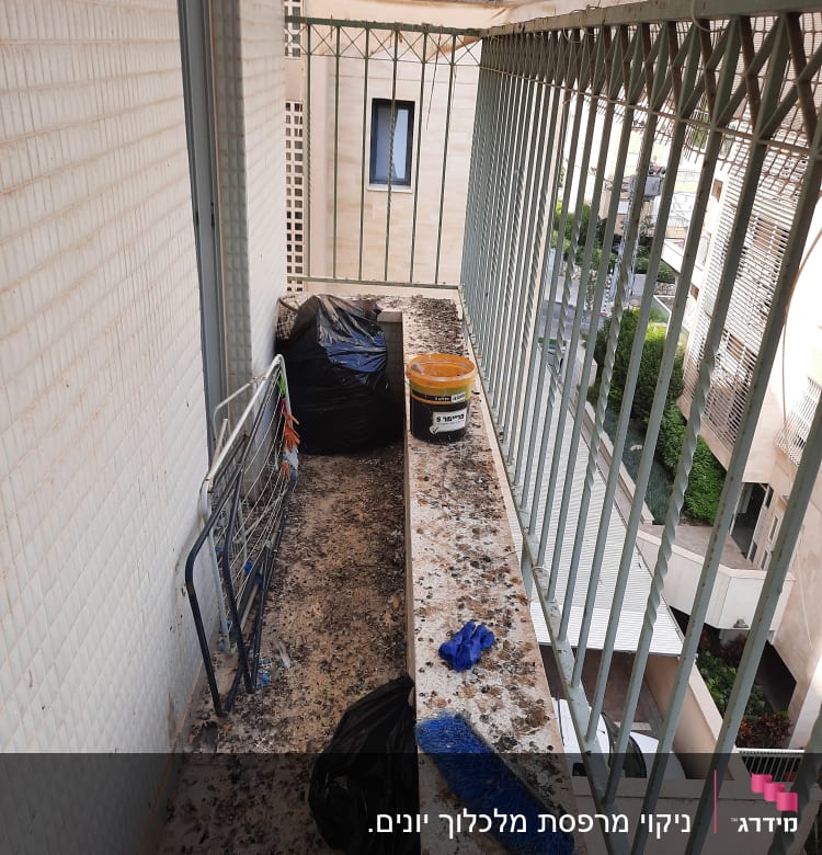 מרפסת עם לכלוך יונים, מטאטא וכפפות כחולות